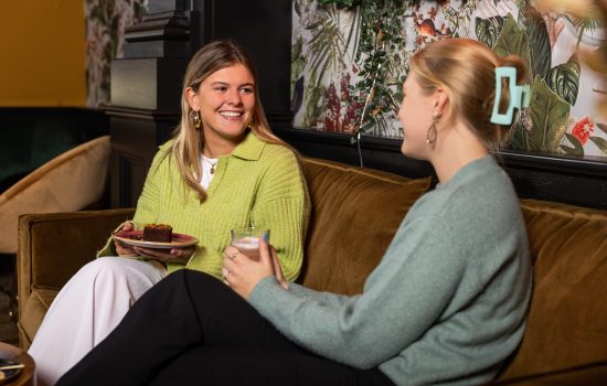 twee vrouwen zitten op de bank bij Loev Enschede